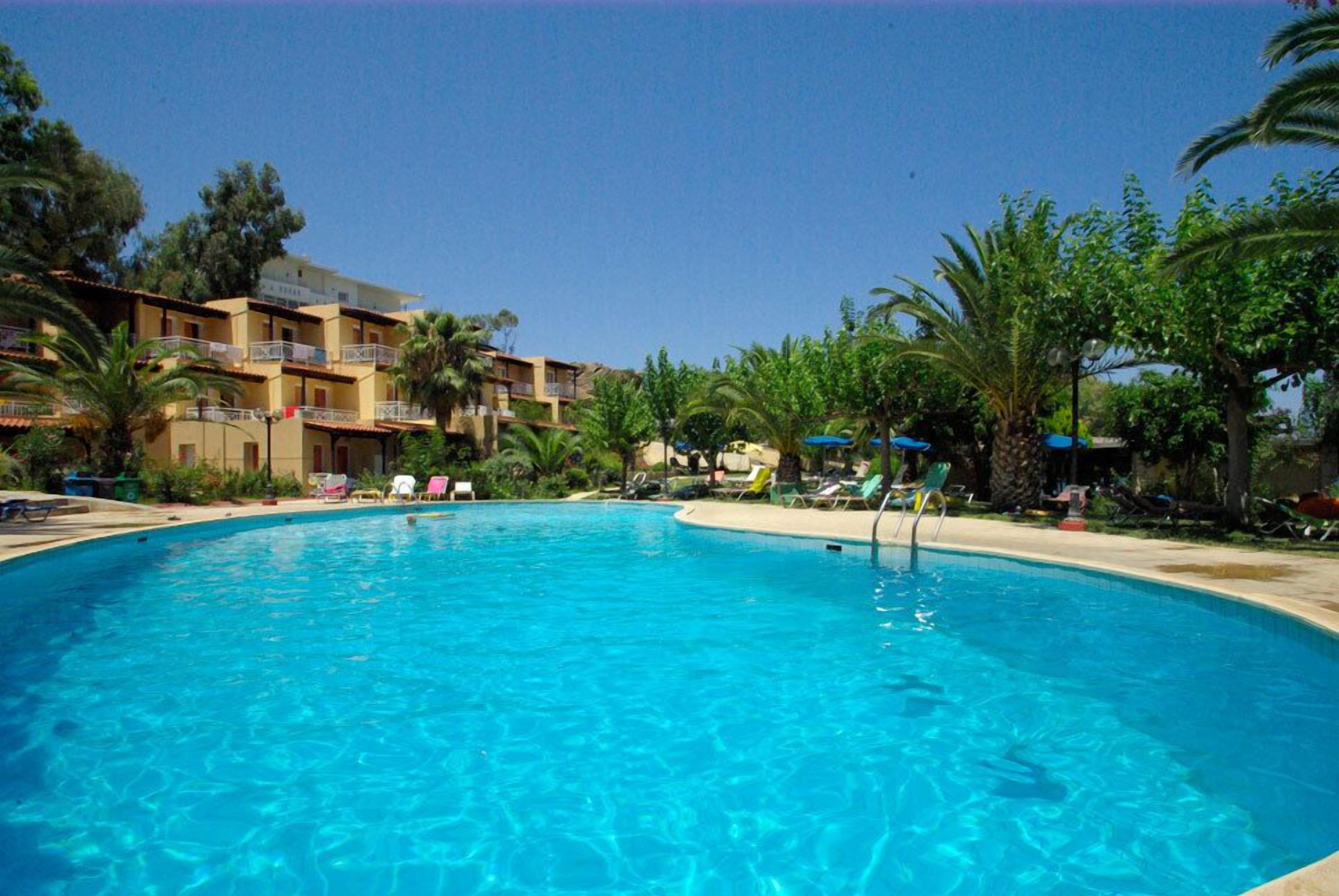 Una piscina al aire libre, sombrillas, tumbonas