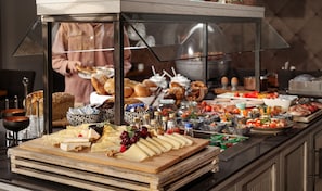 A buffet with various cheeses, fruits, and breads. - Hotel Traumschmiede (Unterneukirchen)