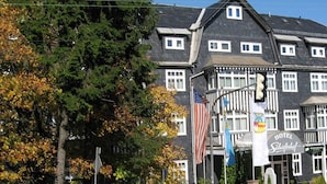 Un hôtel à la façade sombre, doté de nombreuses fenêtres et arborant plusieurs drapeaux, dont le drapeau américain.