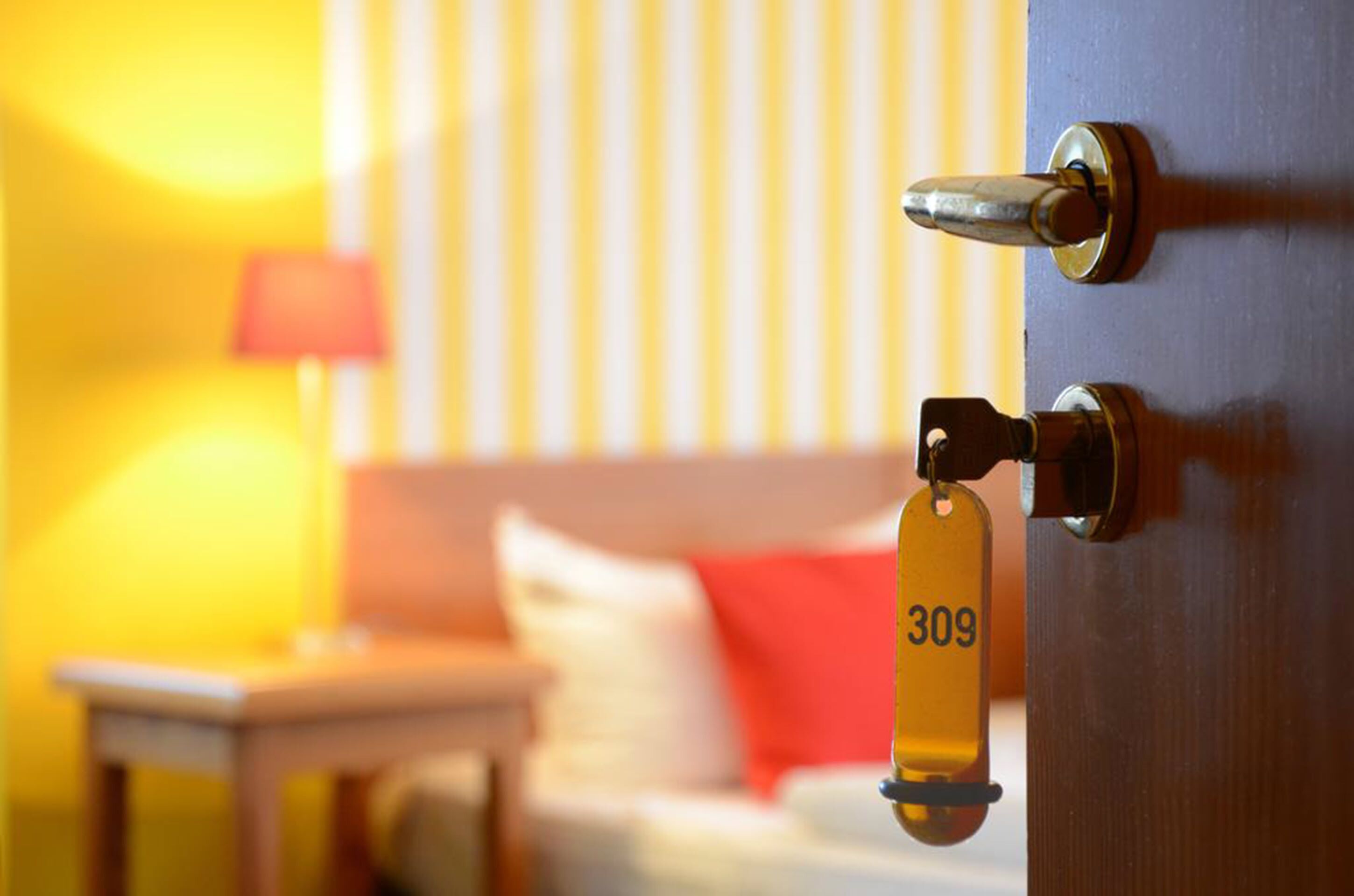 Porta de quarto de hotel com leitor de cartão-chave e etiqueta numérica.