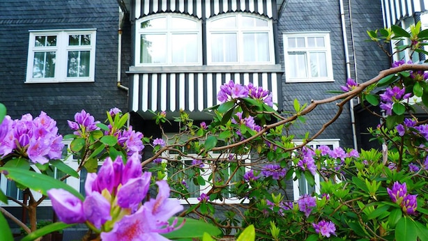 Une maison à l’extérieur sombre, avec des moulures blanches autour des fenêtres et de la porte.