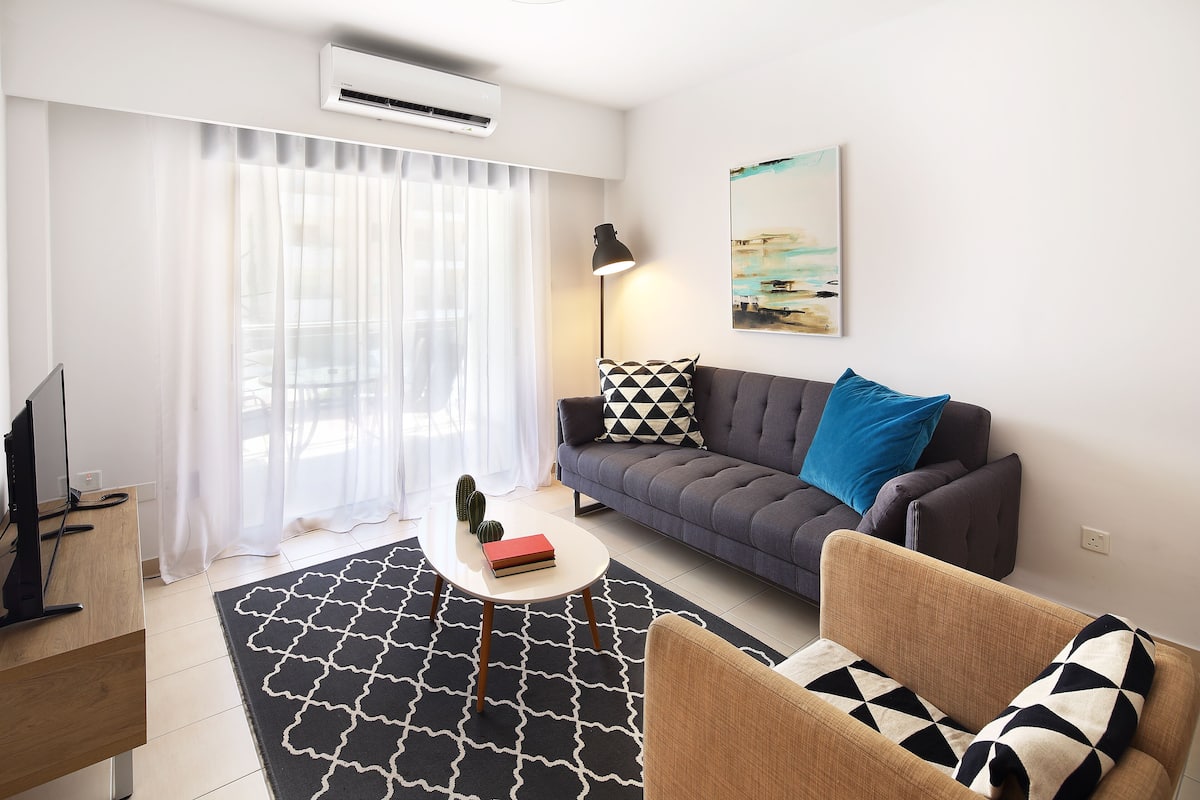 Una sala moderna con un sofá, una mesa de centro y un televisor.