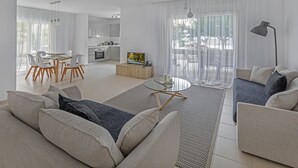Una sala moderna con un sofá, una mesa de centro y un comedor con sillas.