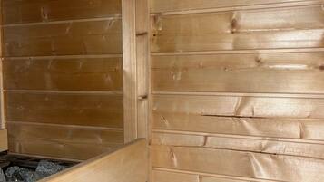 A sauna with wooden walls and a stone bench.