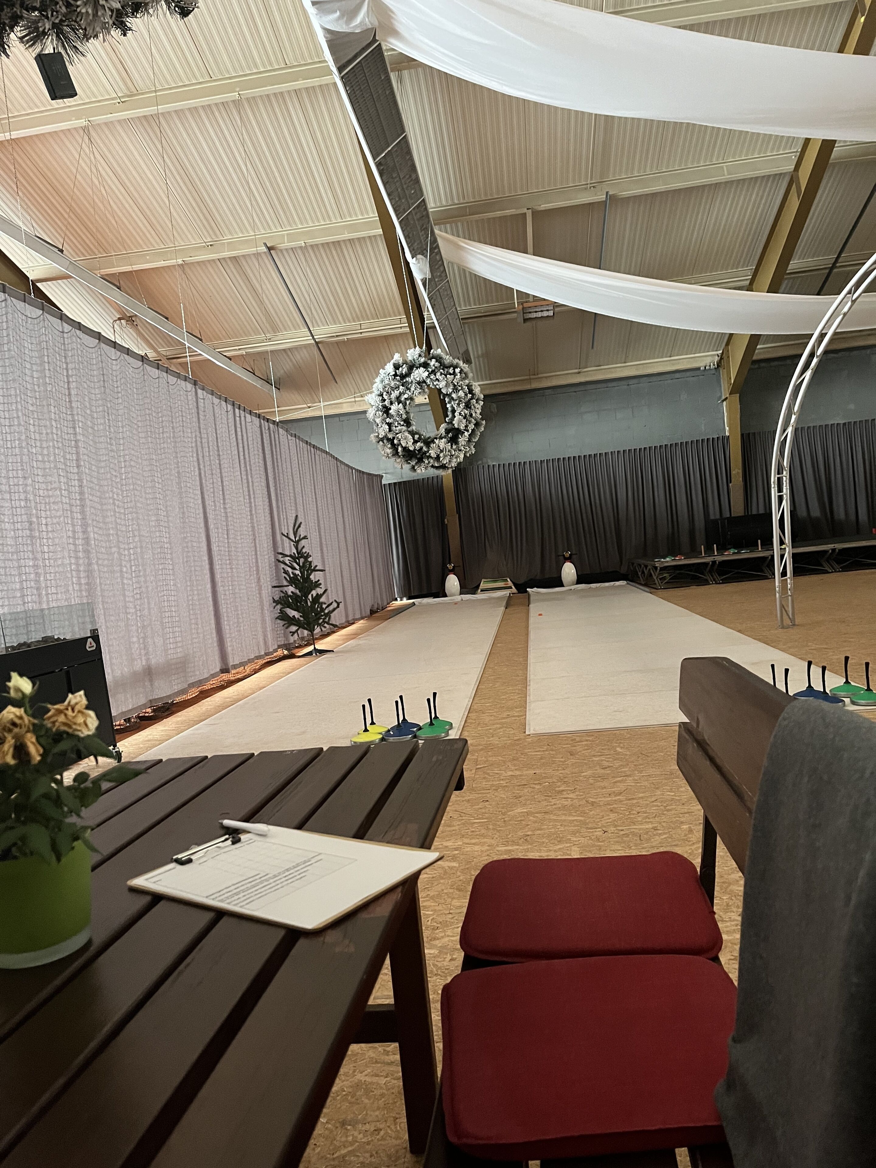 Une salle avec une scène, une table avec un menu et une chaise rouge.