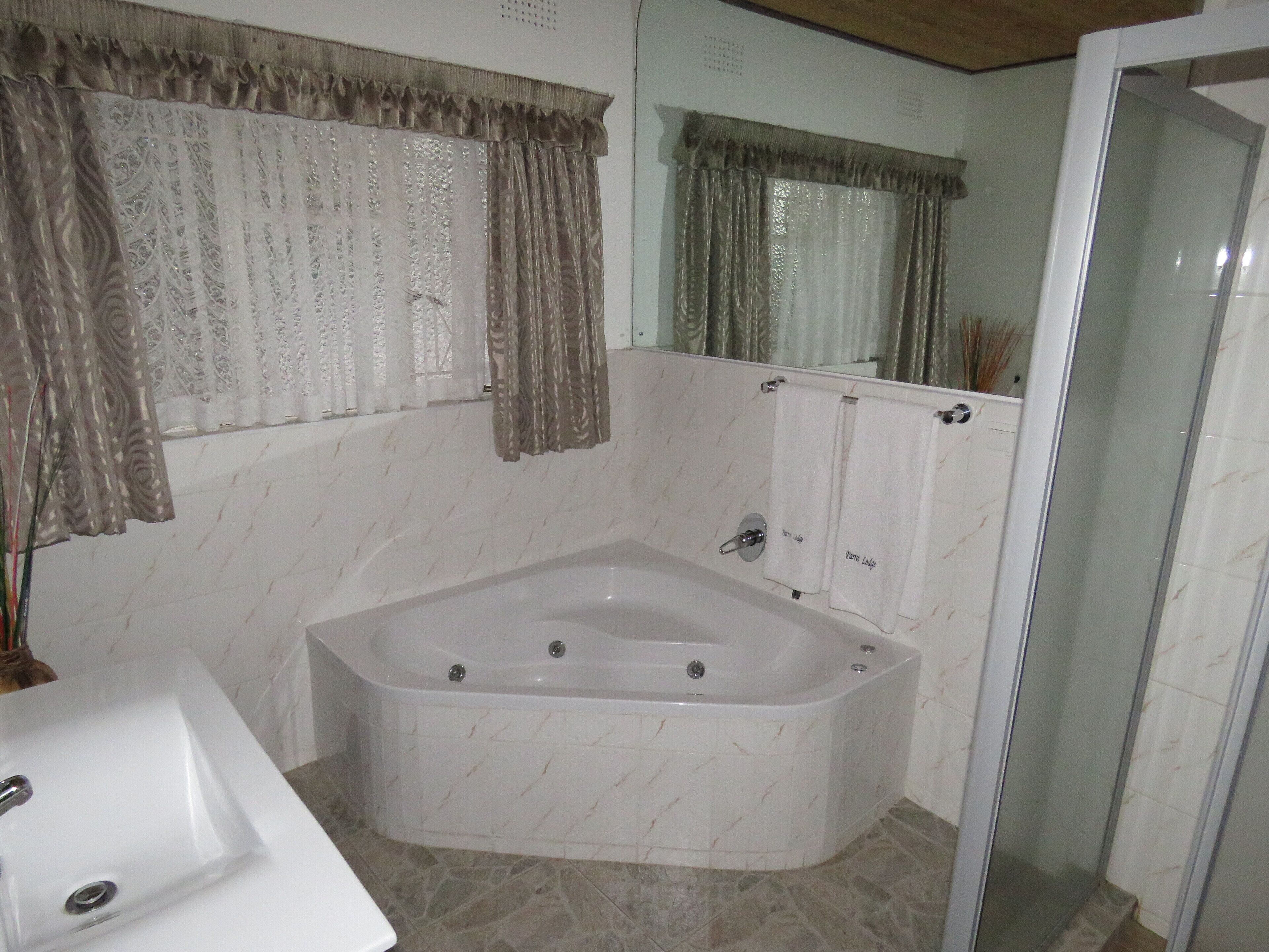 A bathroom with a freestanding bathtub, a sink, and a glass shower enclosure.