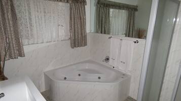 A bathroom with a freestanding bathtub, a sink, and a glass shower enclosure.