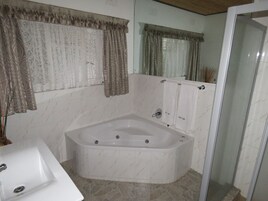 A bathroom with a freestanding bathtub, a sink, and a glass shower enclosure.