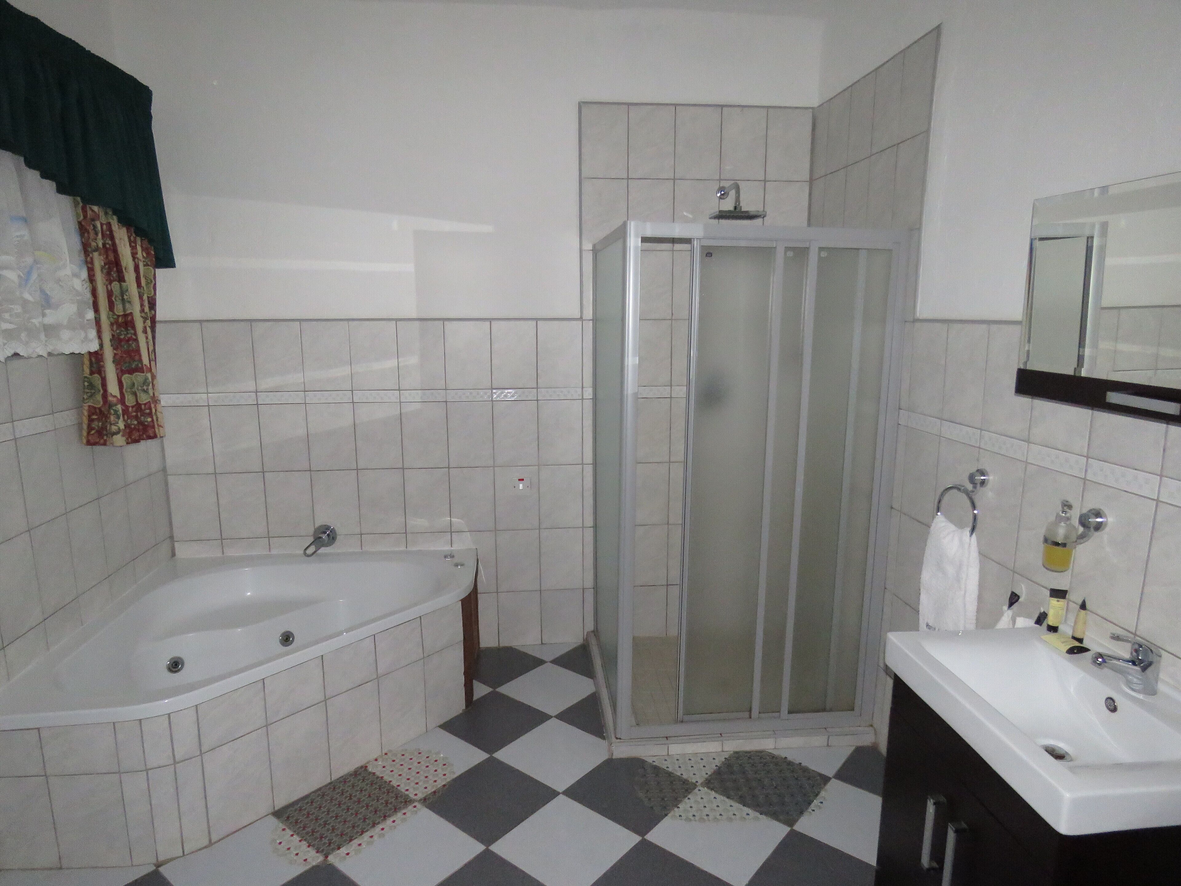 A bathroom with a bathtub, a shower enclosure, and a sink.