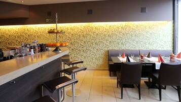 Un restaurant doté d’un bar, de tables et d’un mur décoratif.