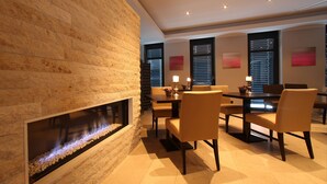 Un área de comedor moderna con chimenea de piedra, una mesa redonda y sillas cómodas.