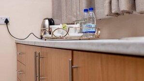 A kitchen counter with a water dispenser, glasses, and a kettle. - Bulawayo Central Lodge (Bulawayo)