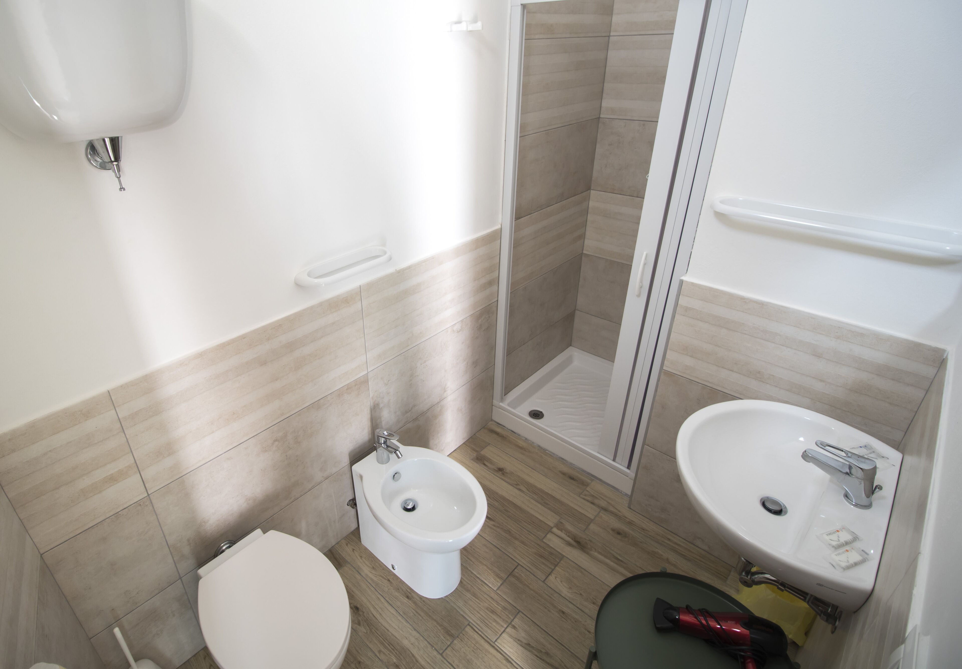 Un baño con inodoro, bidé, ducha y lavabo.
