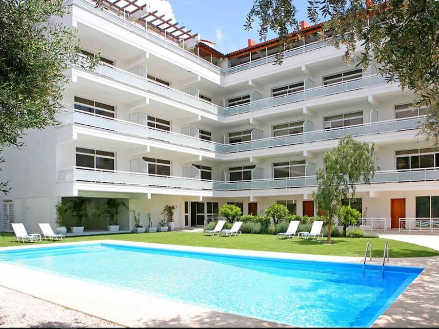 Een buitenzwembad, ligstoelen bij het zwembad