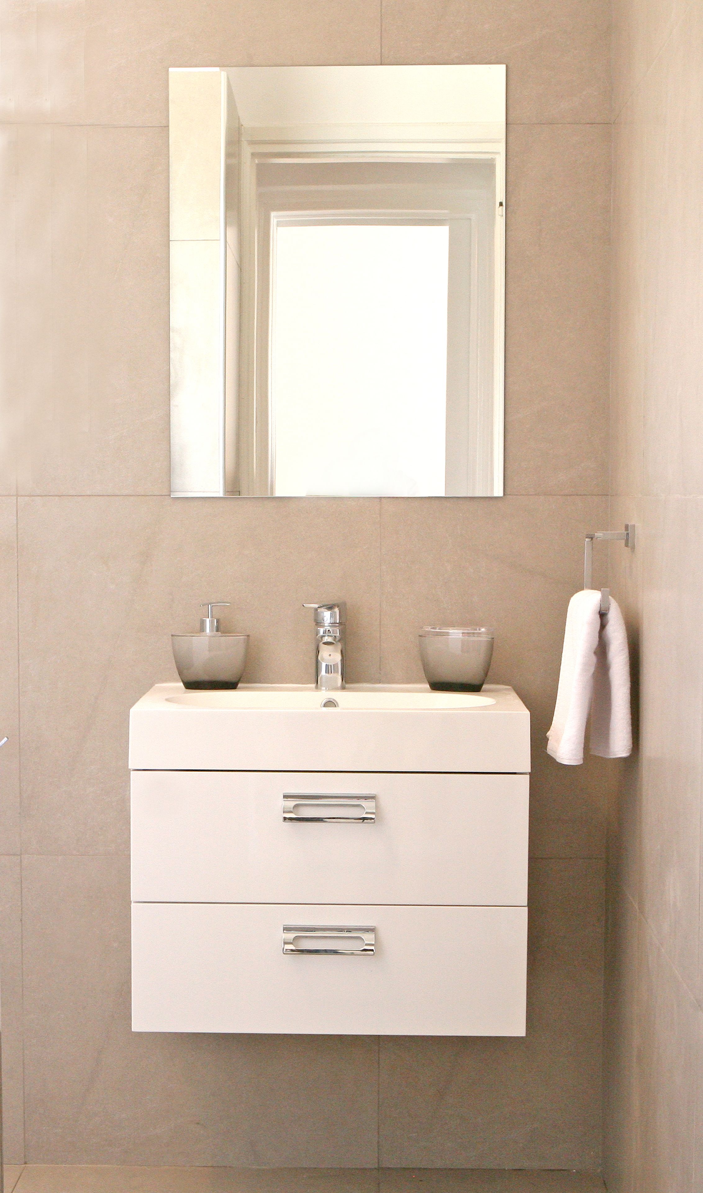 A modern bathroom with a white vanity, two bowls, a faucet, and a towel rack.