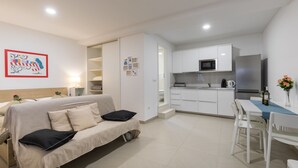 A modern apartment with a kitchenette, a dining area, and a living room with a sofa. - Apartments Ivana (Dubrovnik)