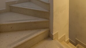 A set of beige stairs with a curved wall on the right. - Apartments Ivana (Dubrovnik)
