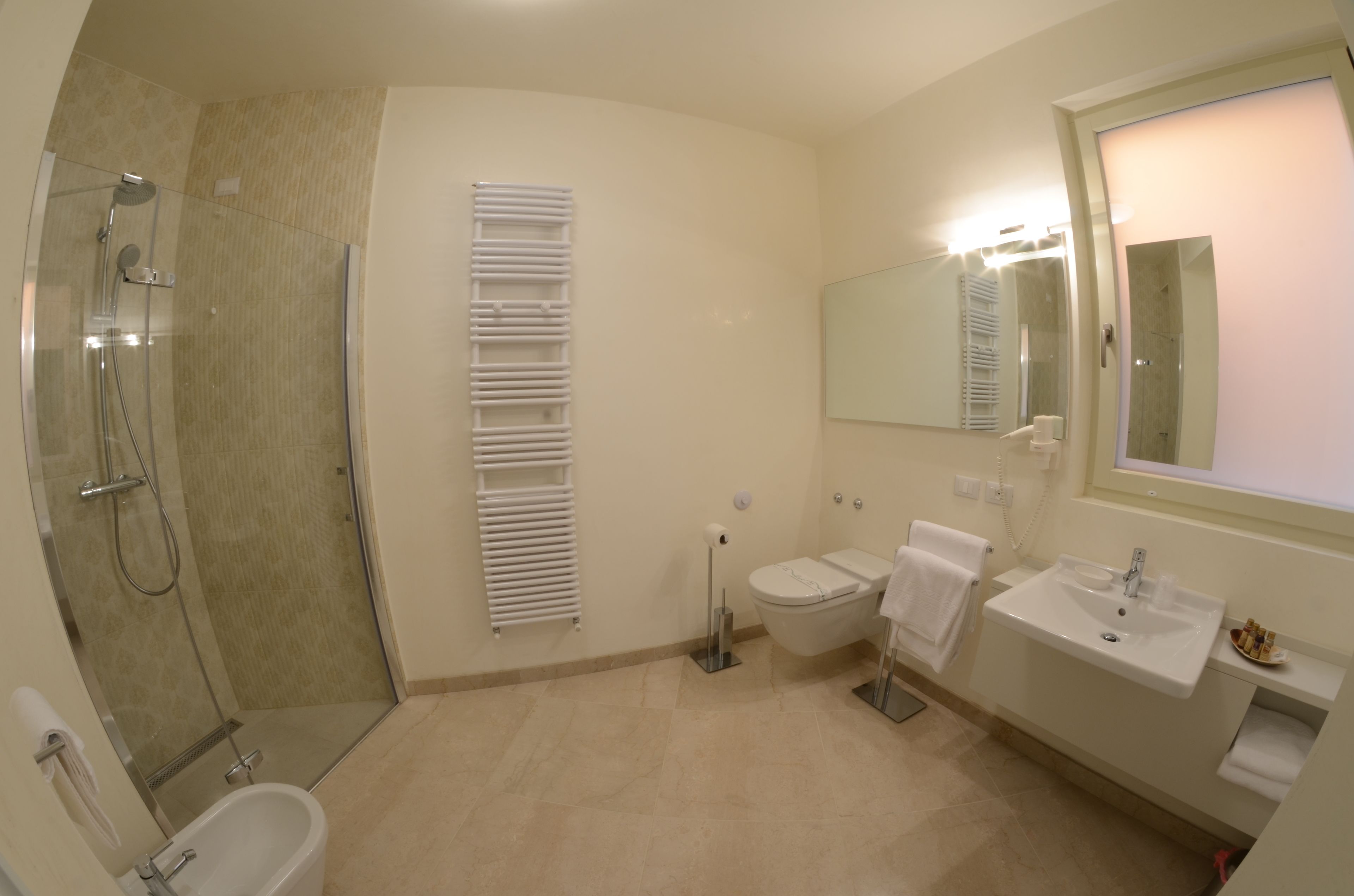 Une salle de bain moderne avec une douche à parois de verre, des toilettes, un lavabo et un miroir.