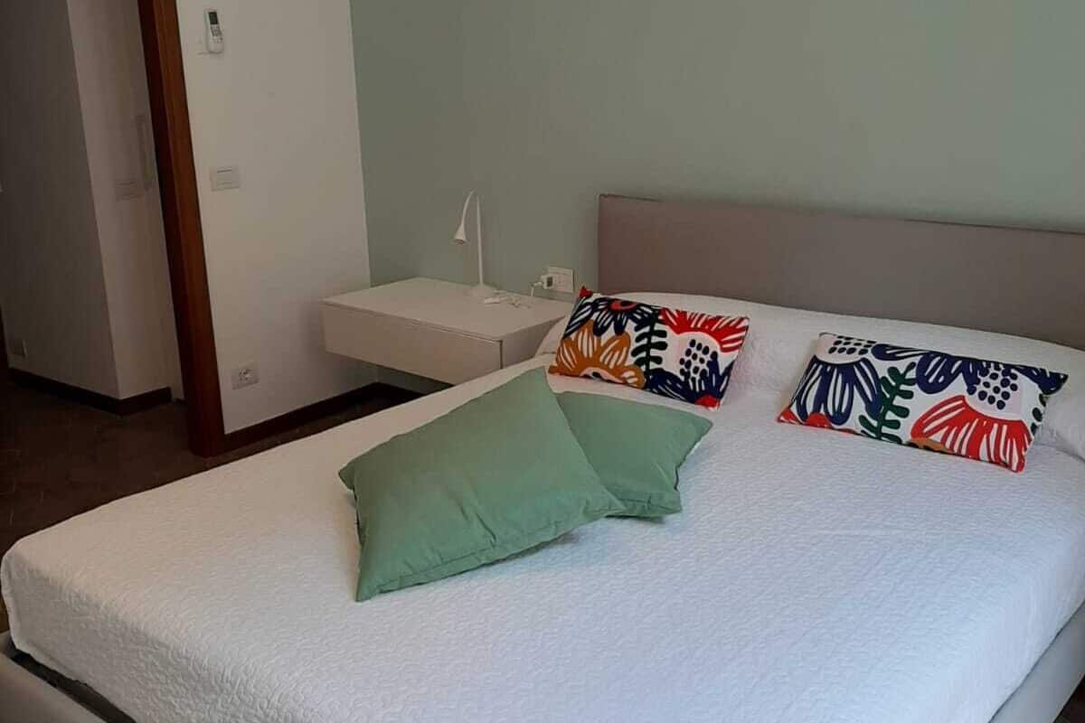 A bedroom with a bed, a nightstand, and a door.
