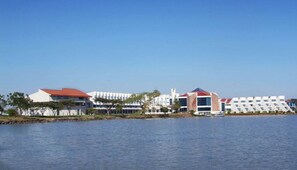 A waterfront hotel with multiple buildings, including a distinctive building with a red roof and a modern structure with a unique geometric design. - Blue Nile Resort (Bahir Dar)