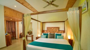 A bedroom with a wooden bed frame, a large bedspread, and a canopy. There is a wooden headboard, bedside tables with lamps, and curtains. - Mistletoe Munnar (Devikolam)
