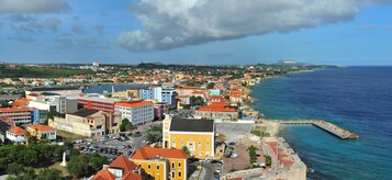 A coastal town with colorful buildings, a marina, and a clear view of the sea.