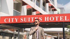 A hotel sign with the name "CITY SUITES HOTEL" and a modern building with balconies. - Majestic City Suites & Beach Hotel (Willemstad)