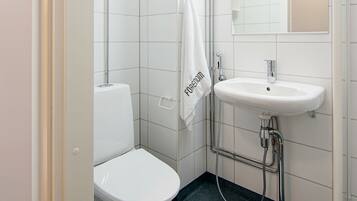 A modern bathroom with a white toilet, a sink, and a mirror.