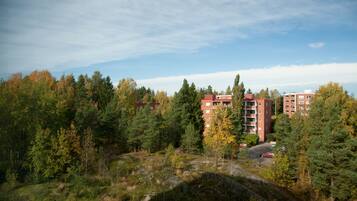 Un edificio de varios pisos rodeado de un bosque frondoso y un cielo despejado.