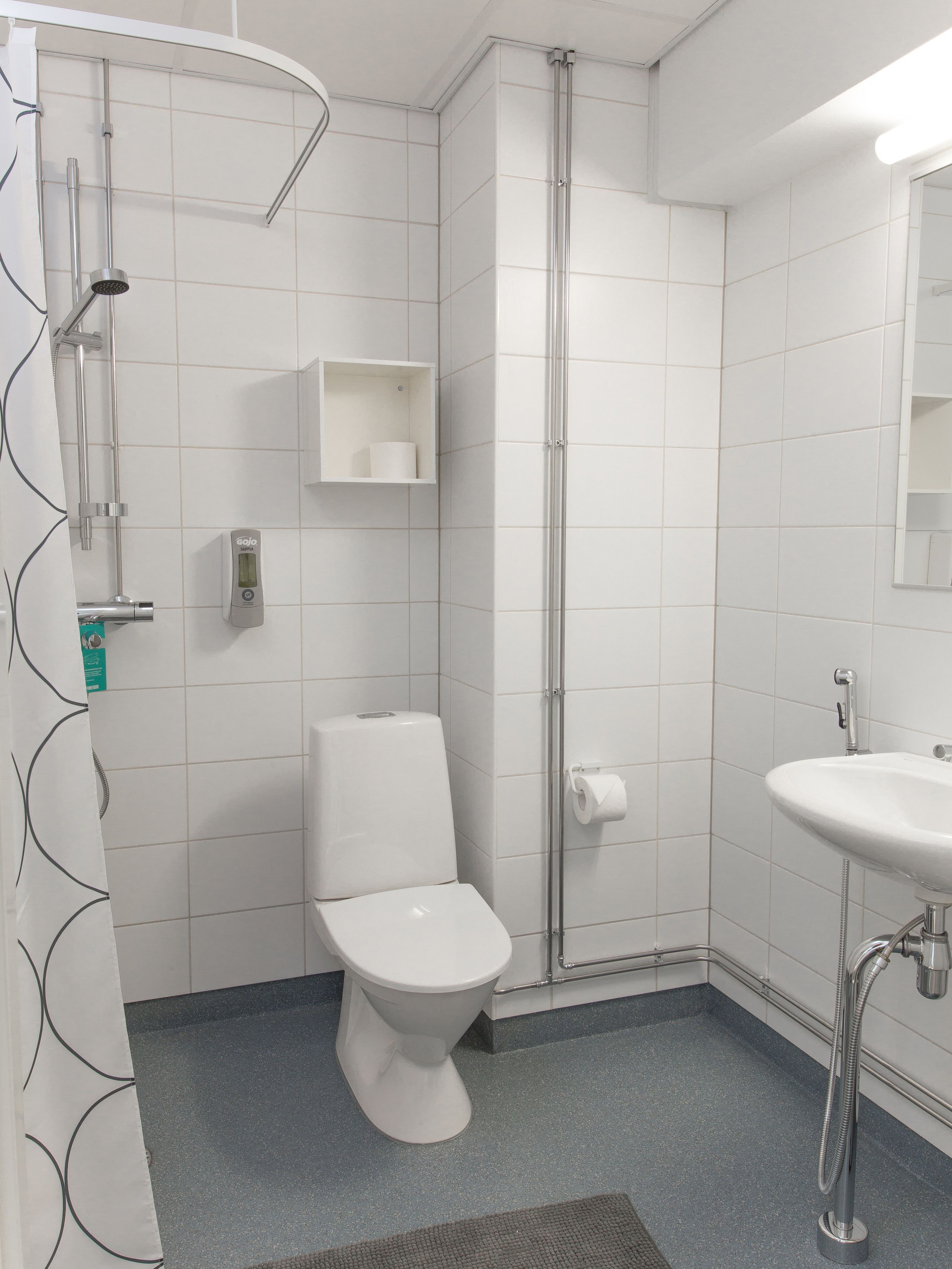 Un baño moderno con inodoro, ducha y lavamanos.