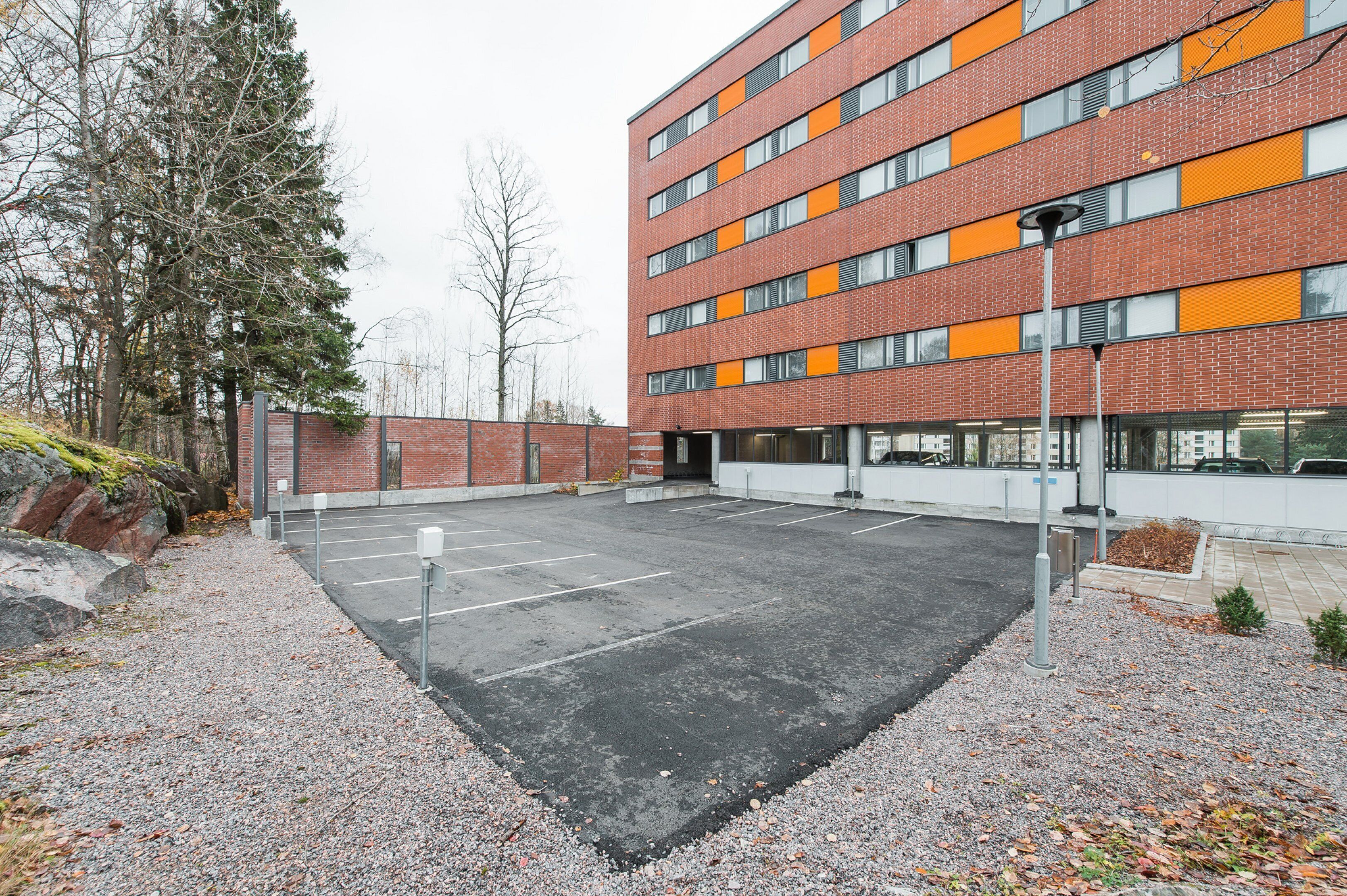A multi-story building with a parking lot in front.