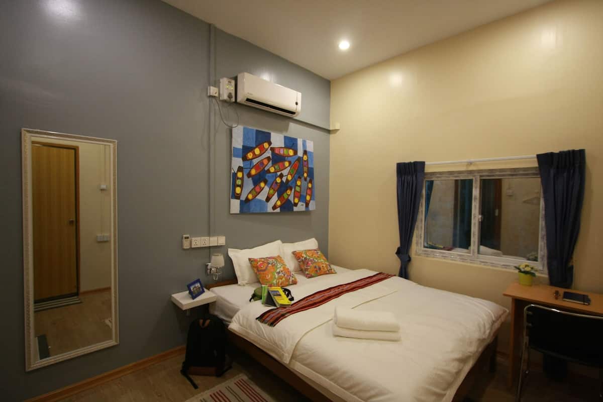 Ein Hotelzimmer mit einem Bett, einem Nachttisch und einem Fenster mit Vorhängen.