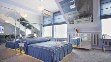 Una habitación de hotel moderna con una cama grande, un escritorio y un ventanal amplio.