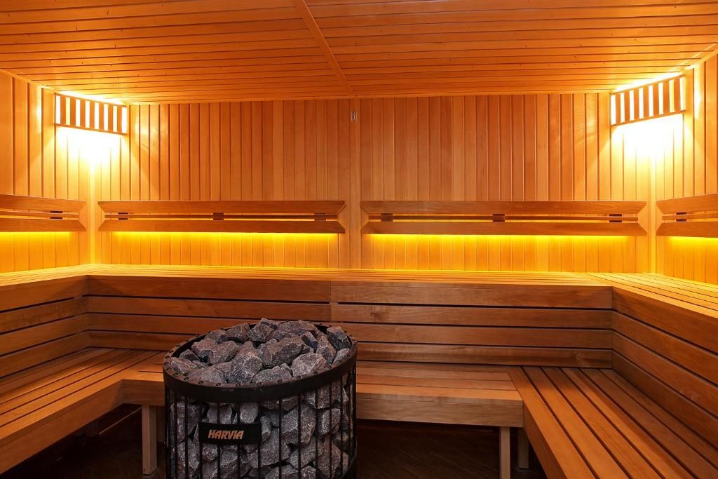 A sauna with wooden benches and a central fire pit.