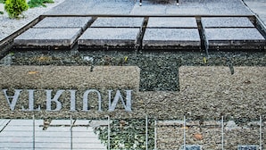 Een atrium met buiten zitplaatsen en een stenen pad dat naar een zwembad leidt.