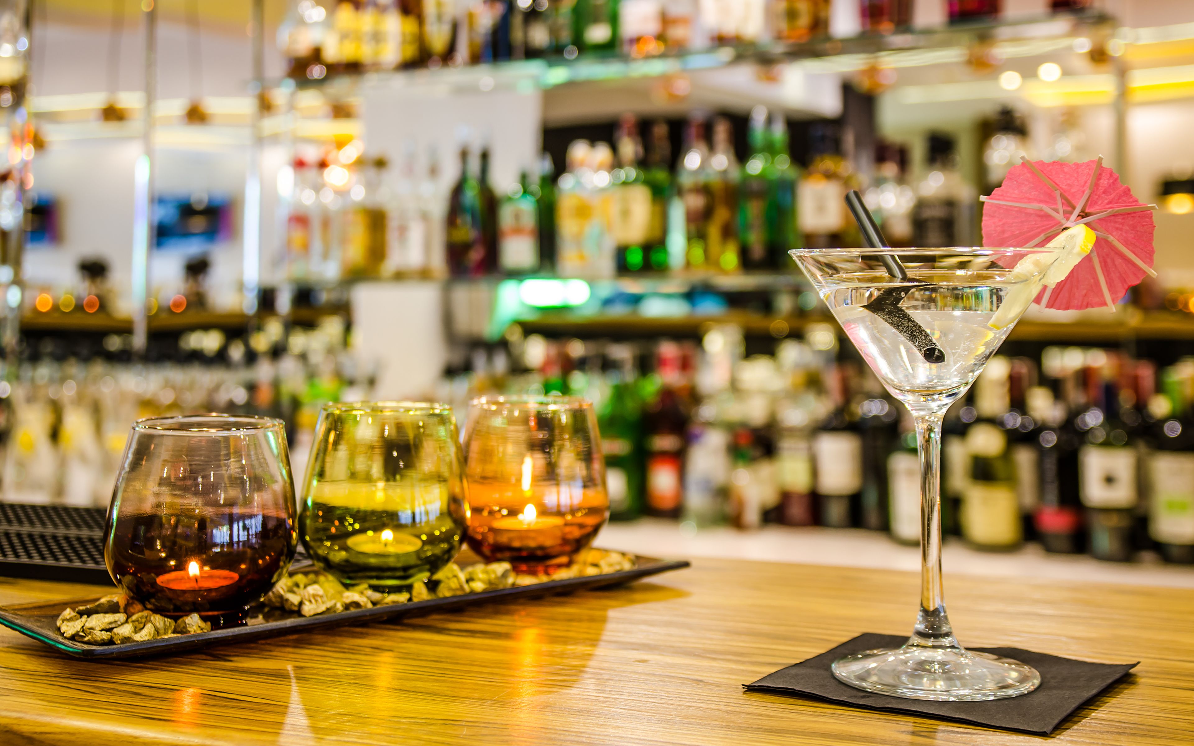 A bar setting with a martini glass and three wine glasses on a tray.