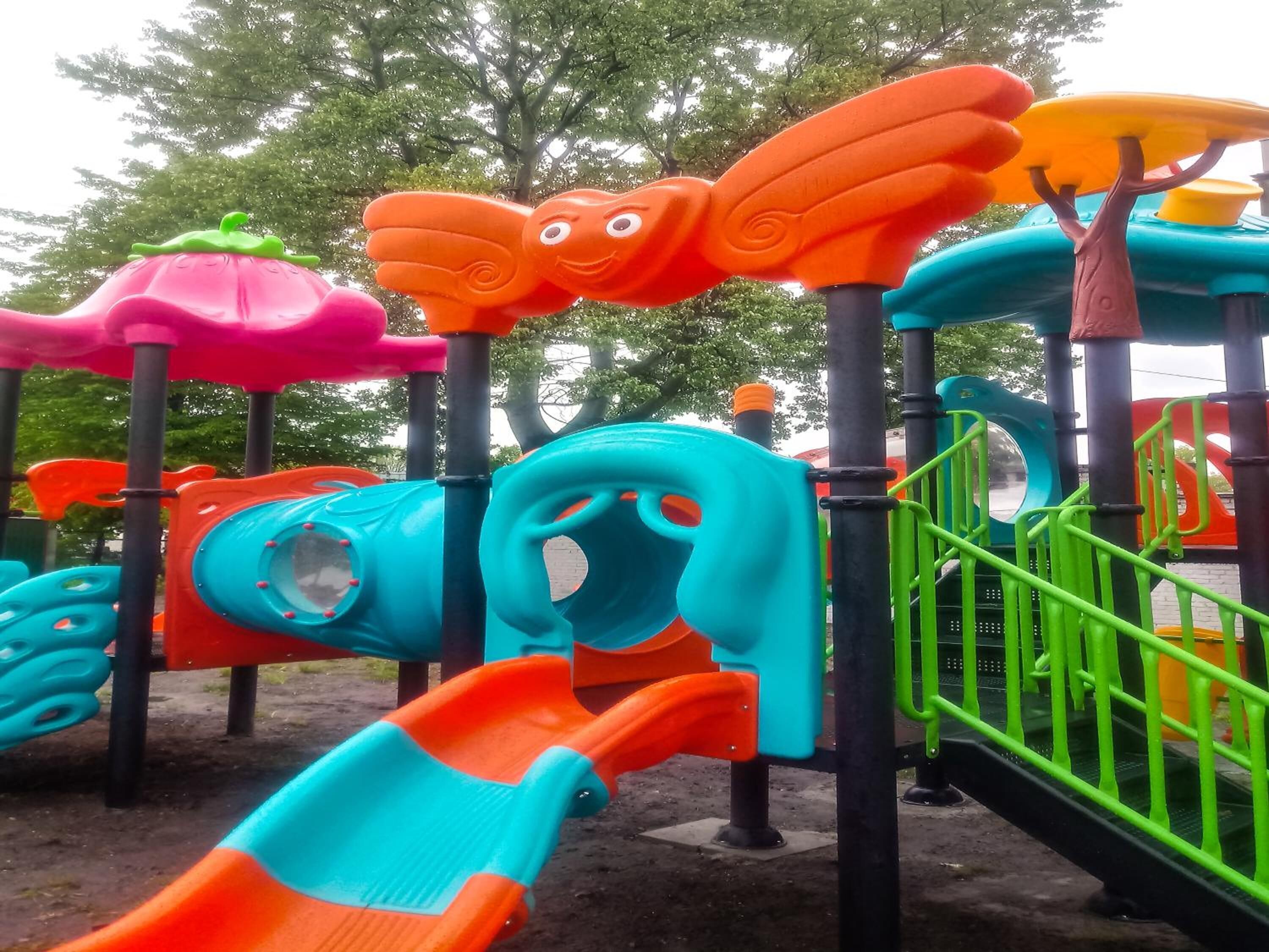 Een speelruimte voor kinderen met diverse kleurrijke constructies en glijbanen.