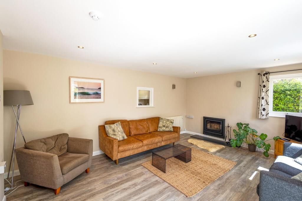A living room with a sofa, a coffee table, a fireplace, and a floor lamp.