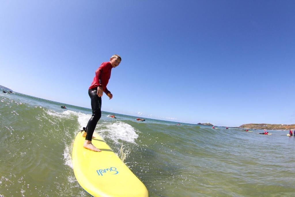 Une personne fait de la planche à voile sur une planche jaune, au large.