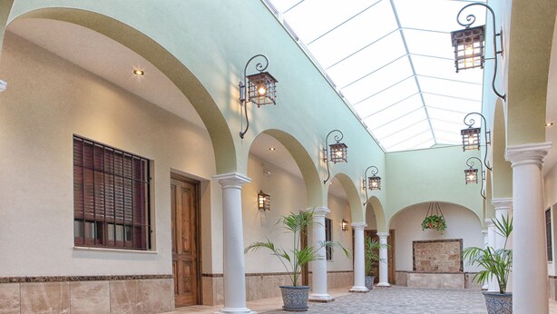 A spacious indoor area with high ceilings, arched columns, and patterned flooring. - Hostal Garlu (La Rambla)