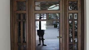 A wooden double door with glass panels and a small plaque above it. - Hostal Garlu (La Rambla)