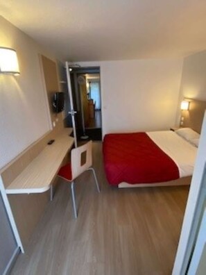 A hotel room with a bed, a desk, a chair, and a TV. - Première Classe Rouen Nord - Bois Guillaume (Bois-Guillaume)