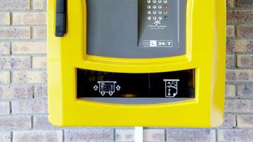 Un terminal d’enregistrement jaune, accessible 24 heures sur 24 et 7 jours sur 7, doté d’une interface à écran tactile et d’un clavier.