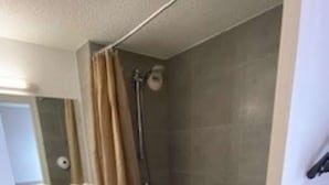 Un baño con ducha, lavabo e inodoro.