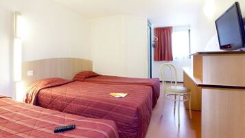 Une chambre d’hôtel avec deux lits, un bureau, une chaise et un téléviseur.