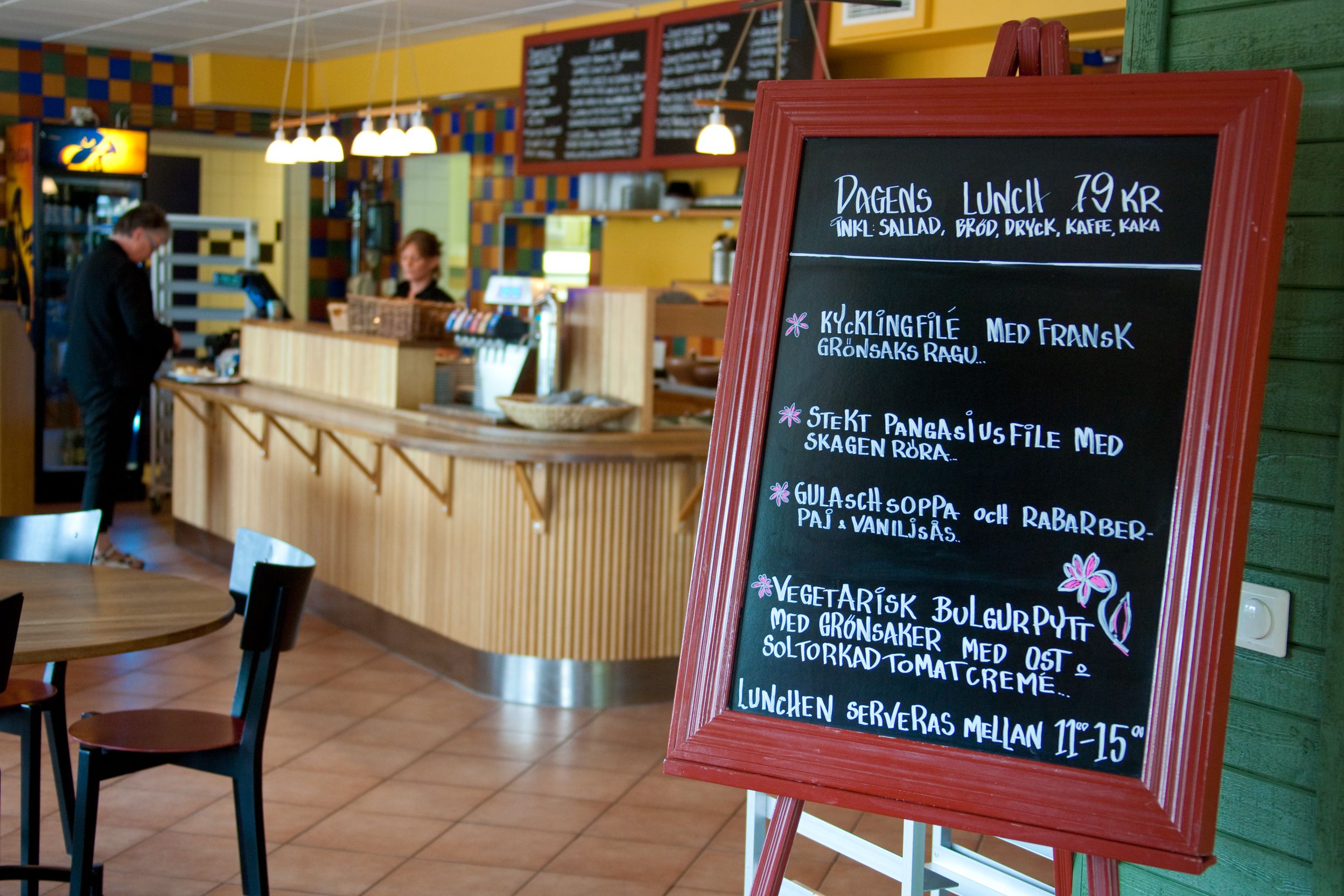 A restaurant with a chalkboard menu listing lunch options and prices.