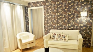 A living room with a white sofa, a white armchair, and a round coffee table. - Jennys Hotell och Restaurang (Arvika)