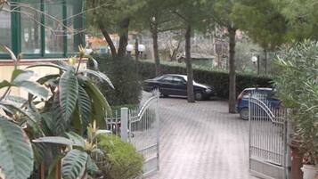 A gated driveway leading to a building with a brick pathway.
