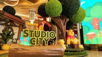 A decorative display with a large tree, a teddy bear, and a sign that reads 'STUDIO CITY'.