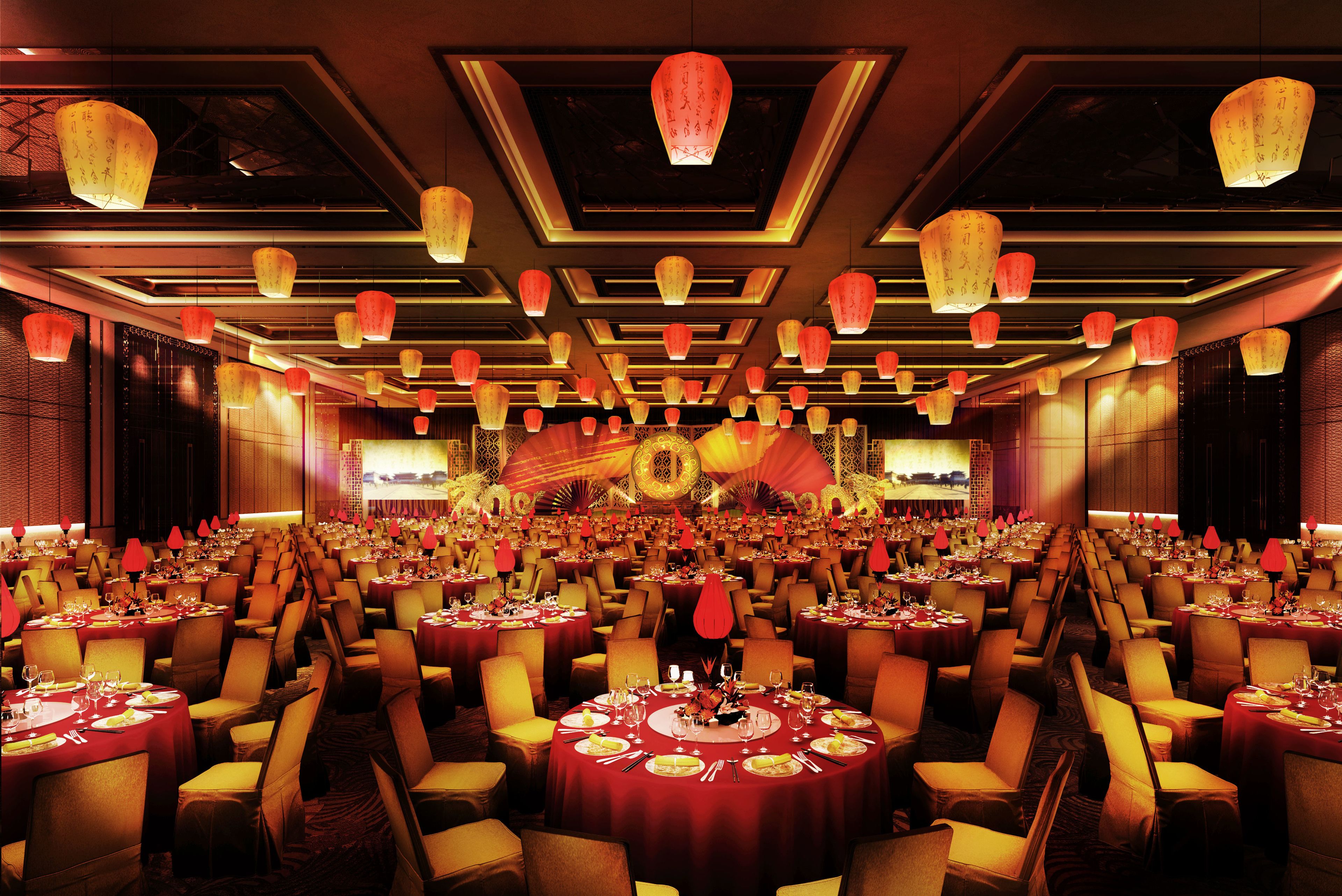 Un salón de banquetes con mesas redondas, manteles rojos y sillas amarillas.